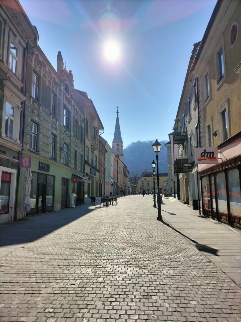 Ruelle pavée avec au bout une des églises de la ville de Celje
