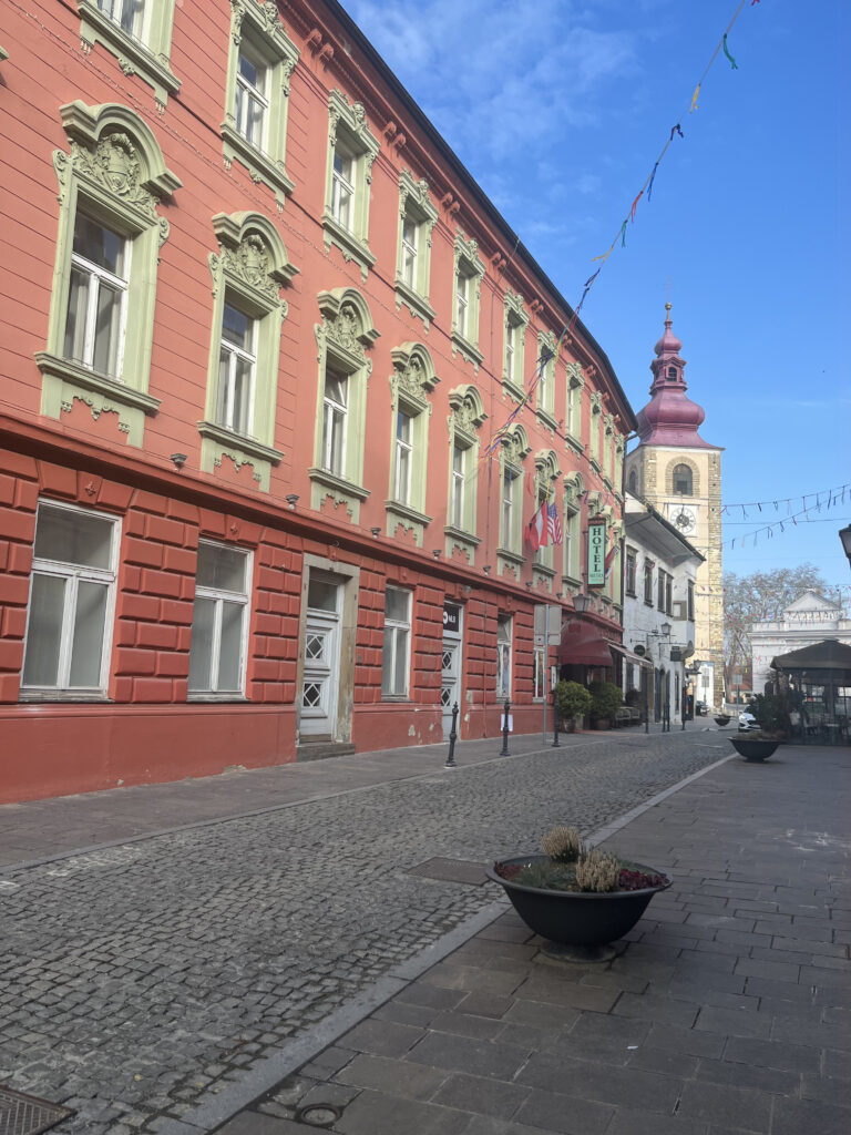Vue sur l'église de Ptuj depuis une ruelle pavée