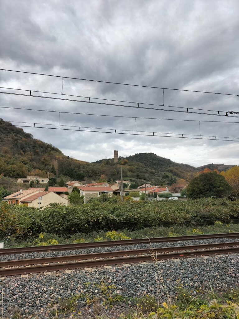 Voie ferrée et vue sur un village dominé par une colline