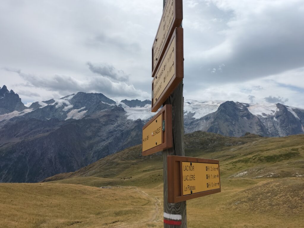 Panneau d'indication au premier plan et montagnes enneigées au second plan